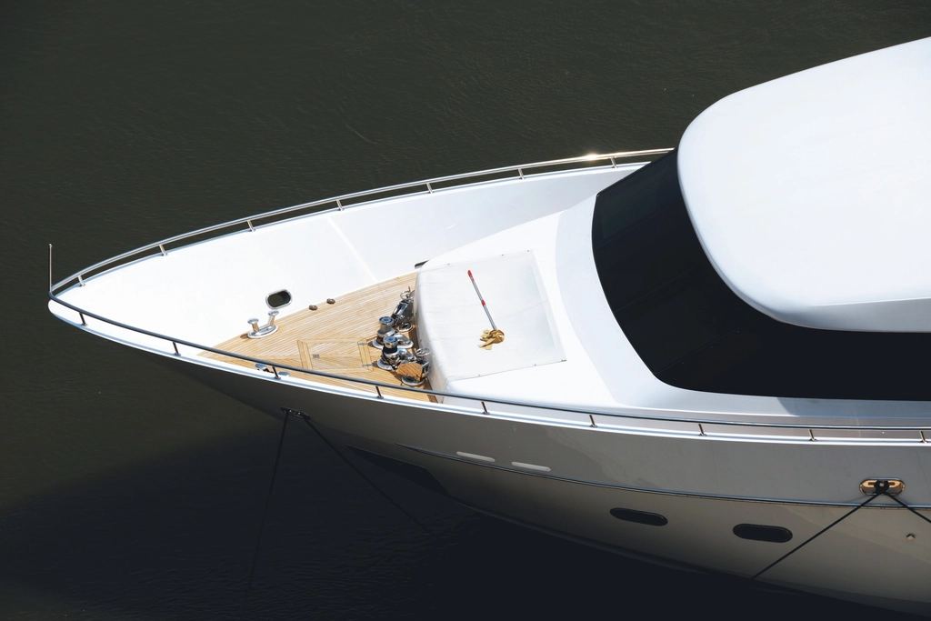 Bow of a white luxury yacht on dark water