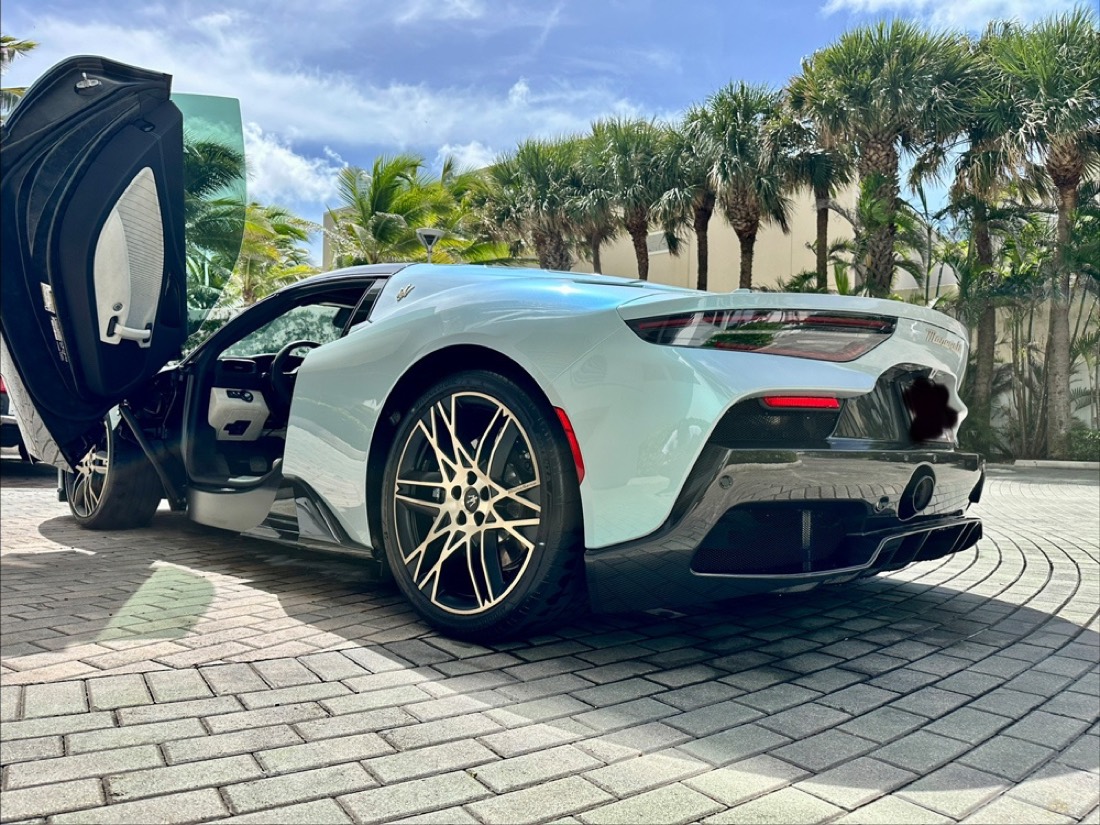 Detailed white Maserati MC20 with its door raised