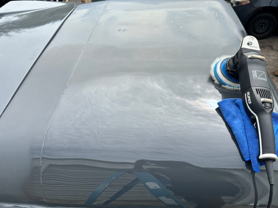 Machine polishing a car hood during paint correction